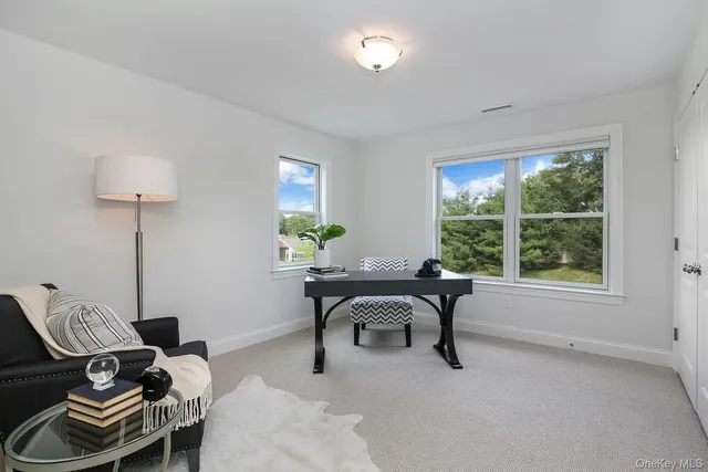 a view of a workspace with furniture and a window
