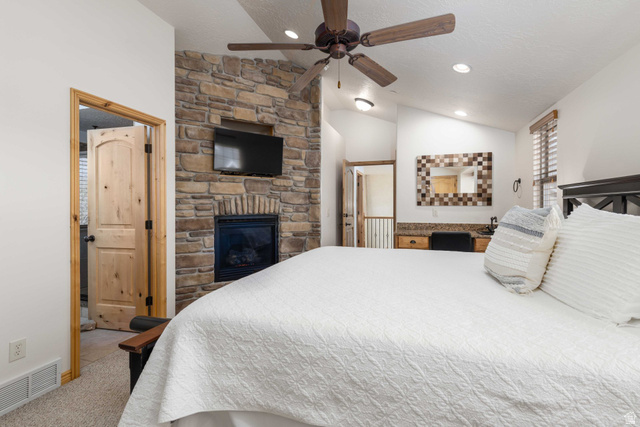 5168 Fairview Loop, Unit C604 Eden, UT 84310 - Photo 22 of 53 Bedroom featuring a stone fireplace, light carpet, and a ceiling fan