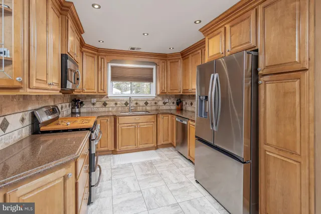 a kitchen with a refrigerator sink and cabinets