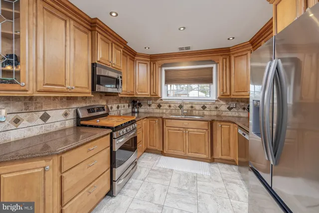 a kitchen with stainless steel appliances granite countertop a refrigerator sink and stove