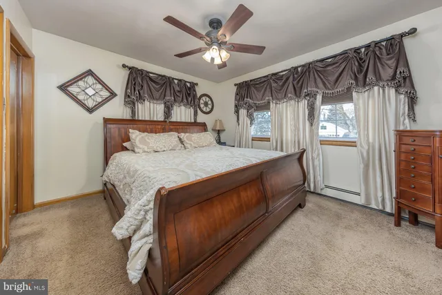 a bedroom with a bed and a ceiling fan