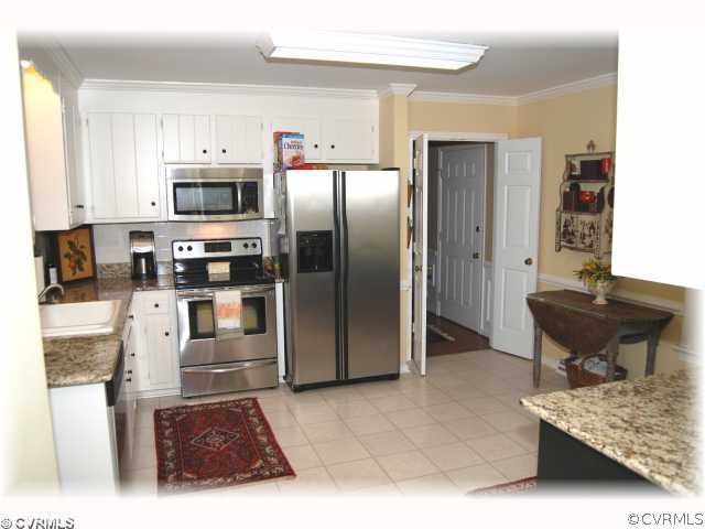 2100 Winterfield Road Midlothian, VA 23113 - Photo 4 of 12 a kitchen with stainless steel appliances kitchen island granite countertop a refrigerator and a stove top oven