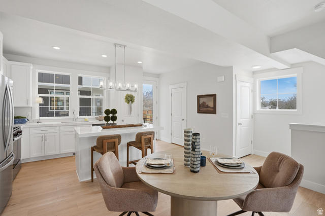 7338 South Seven Tree Lane, Unit 75 Midvale, UT 84047 - Photo 12 of 30 Dining area featuring light wood-style floors, plenty of natural light, and hanging lights