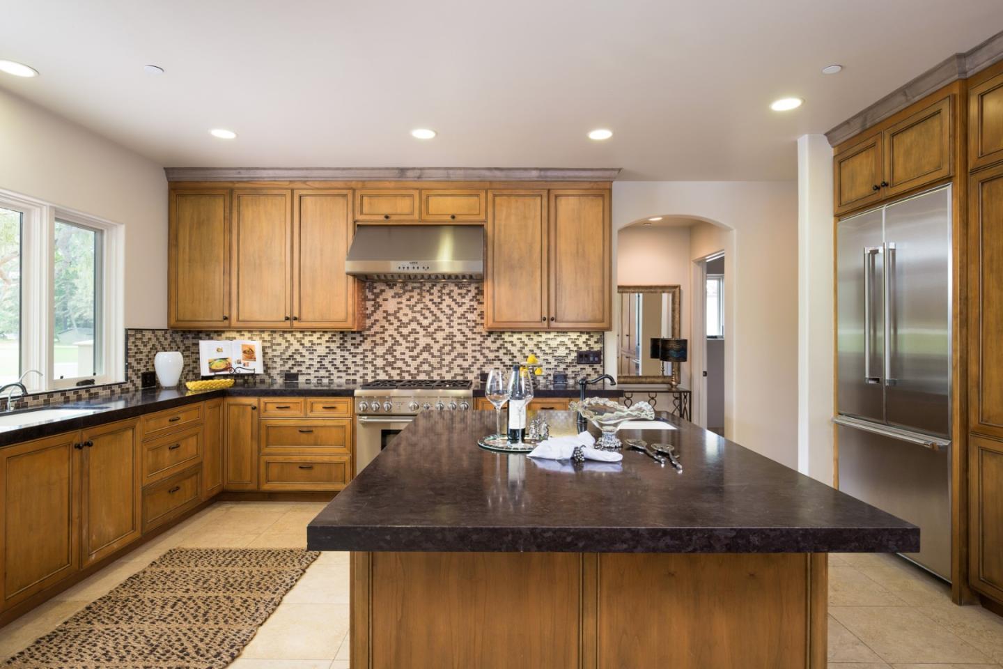 1048 Rodeo Road Pebble Beach, CA 93953 - Photo 9 of 16 a kitchen with kitchen island granite countertop a sink and cabinets