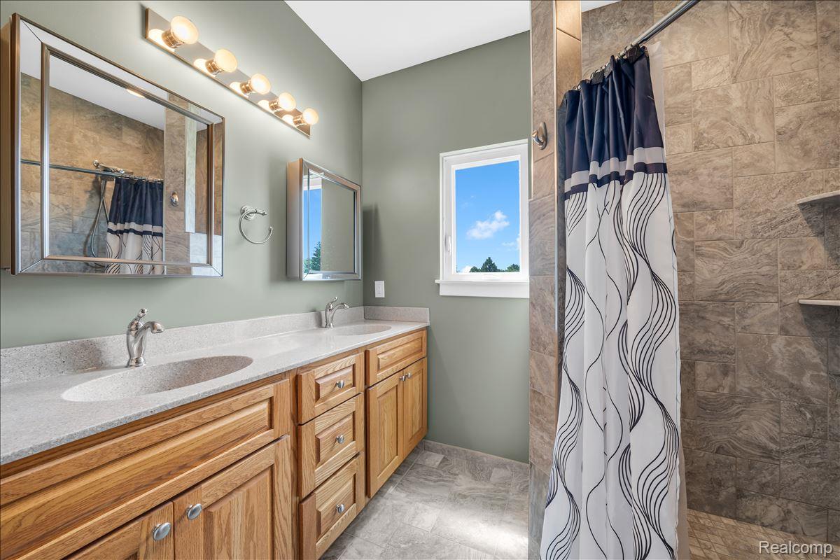 4266 McCandlish Road Grand Blanc, MI 48439 - Photo 28 of 68 Dual vanity with integrated sinks, light-toned countertops, and natural wood cabinetry
