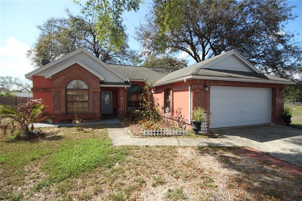 7975 Village Green Road Orlando, FL 32818 - Photo 1 of 1 a front view of a house with a yard and garage