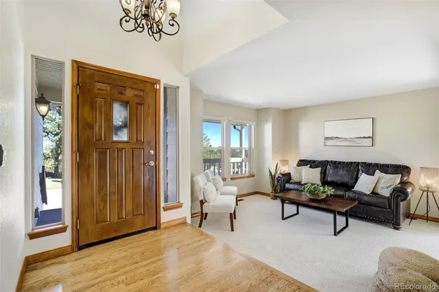 a kitchen with stainless steel appliances granite countertop a refrigerator a stove and a dining table with wooden floor