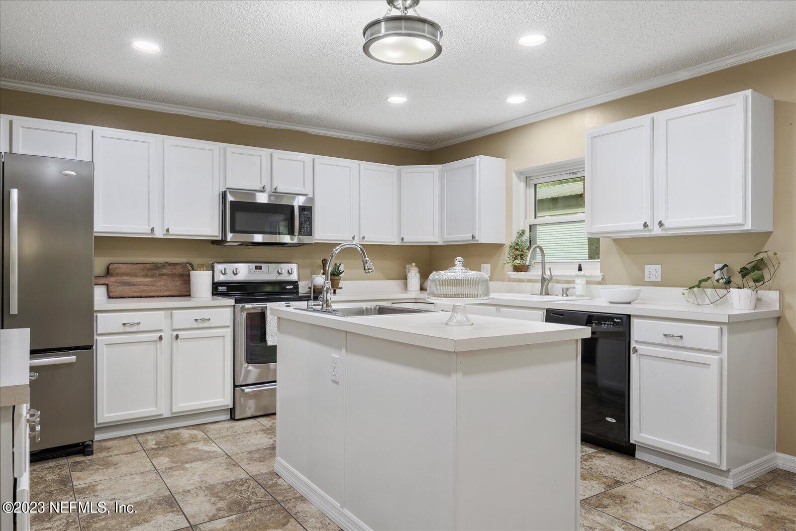 55703 Bear Run Road Callahan, FL 32011 - Photo 16 of 58 a kitchen with a sink a stove a refrigerator and cabinets