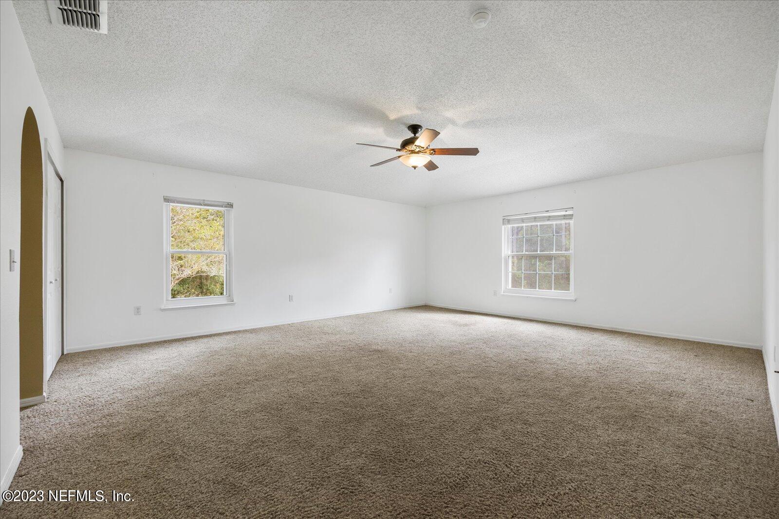 55703 Bear Run Road Callahan, FL 32011 - Photo 25 of 58 an empty room with windows and chandelier fan