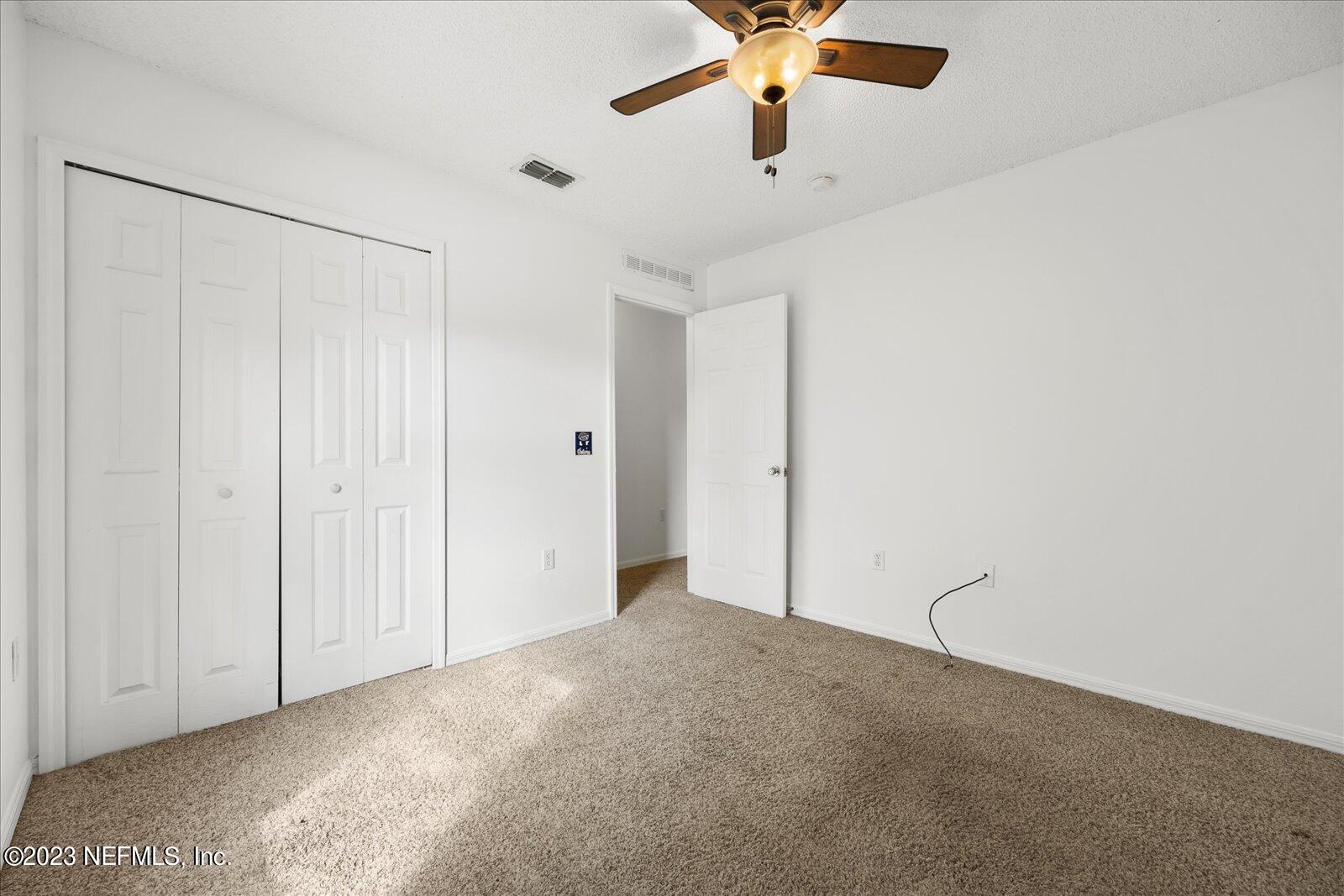 55703 Bear Run Road Callahan, FL 32011 - Photo 37 of 58 an empty room with a ceiling fan and carpet