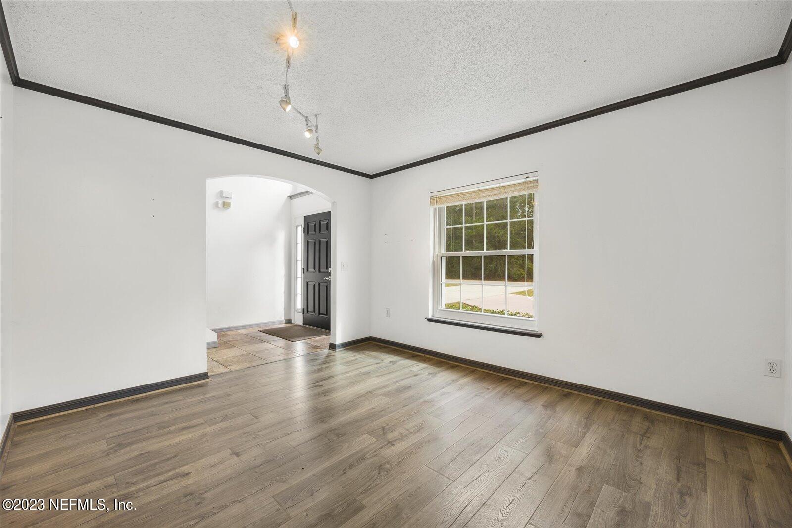 55703 Bear Run Road Callahan, FL 32011 - Photo 7 of 58 a view of an empty room with wooden floor and a window