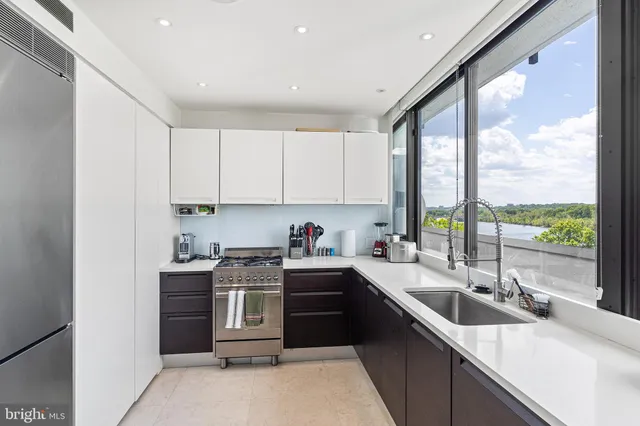 a kitchen with a sink stove top oven and cabinets