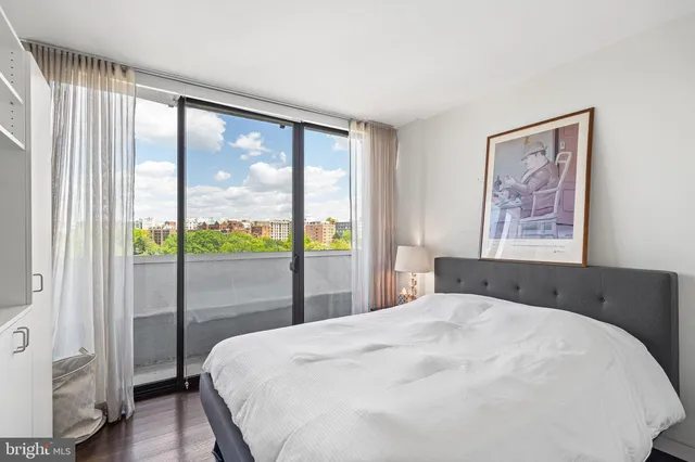a bedroom with a large window and a balcony