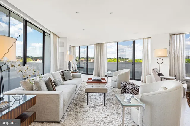 a living room with furniture and large windows