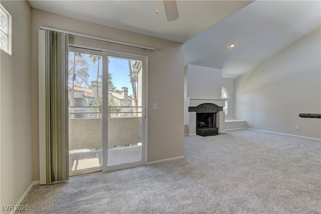 Unfurnished living room with carpet, healthy amount of natural light, ceiling fan, and baseboards