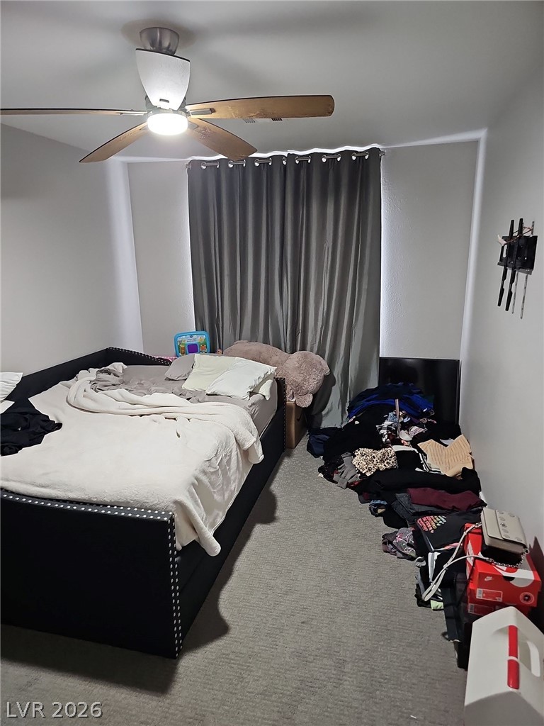 1418 Reebok Terrace Henderson, NV 89014 - Photo 13 of 38 Relax in this well-appointed bedroom featuring cozy carpet flooring and a ceiling fan for optimal comfort.