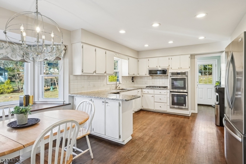 15 Southview Road Randolph, NJ 07869 - Photo 14 of 39 a kitchen with stainless steel appliances granite countertop a refrigerator oven a stove top oven a large island with wooden floor and cabinets