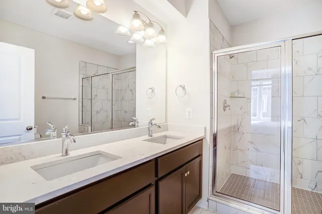 a bathroom with a double vanity sink mirror and shower