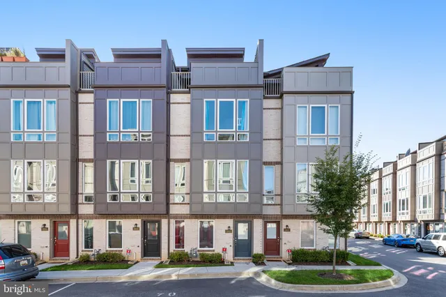 a front view of a building with a yard and plants