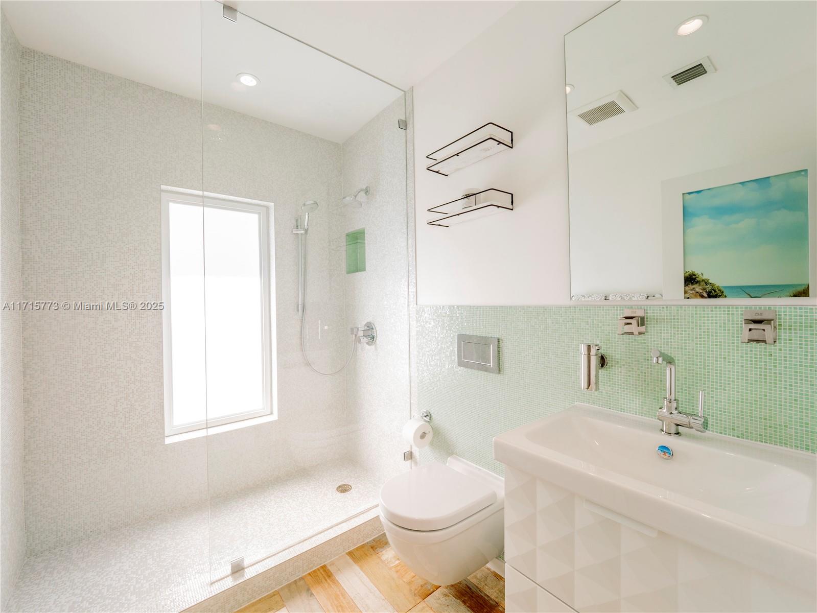 4365 North Bay Road Miami Beach, FL 33140 - Photo 23 of 35 a bathroom with a sink a toilet and shower