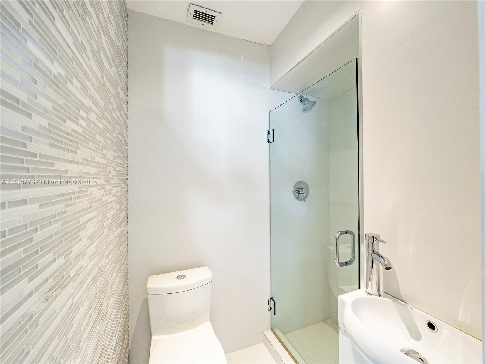 4365 North Bay Road Miami Beach, FL 33140 - Photo 25 of 35 a bathroom with a toilet a sink and shower