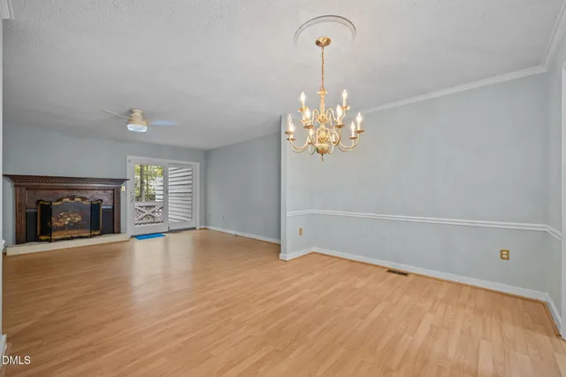 a view of empty room with wooden floor and fireplace