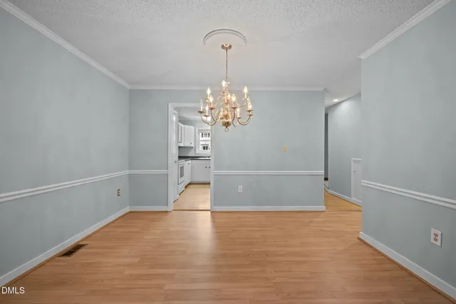 a view of an empty room with wooden floor fireplace and a window