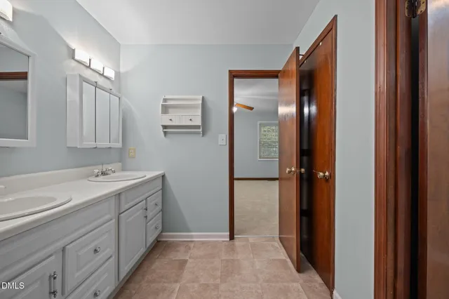an empty room with windows and chandelier fan