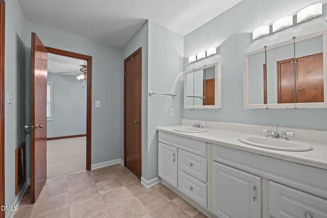 a bathroom with a double vanity sink mirror and shower