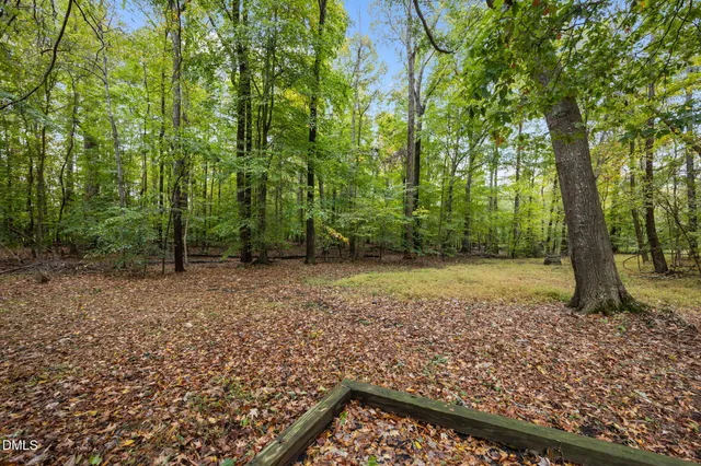 a view of a backyard with wooden fence and a bench