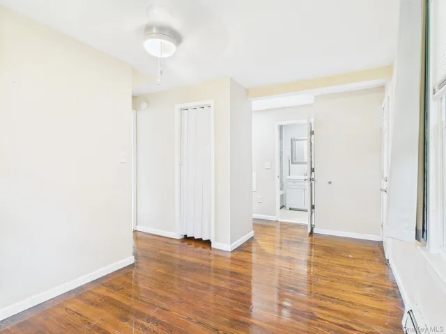 a view of an empty room with wooden floor