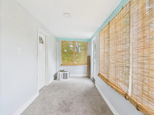 a view of a bedroom with a bed and wooden floor