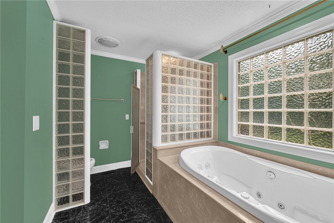 1016 Campbell Road Belton, SC 29627 - Photo 18 of 50 Indulge in a primary bathroom featuring a spacious soaking tub and an elegant glass block shower.