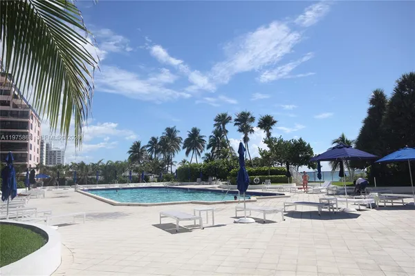 a view of a swimming pool with sitting area and furniture