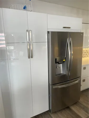 a metallic refrigerator freezer sitting in a kitchen