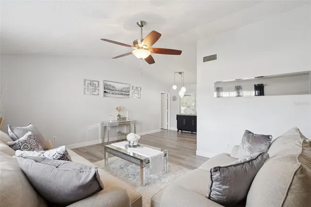 a living room with furniture and a wooden floor
