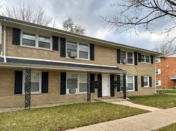 front view of a brick house with a yard