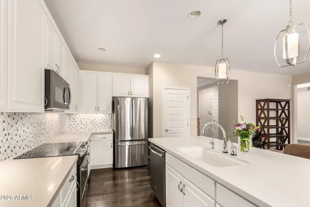 a kitchen with stainless steel appliances a refrigerator sink and wooden floor