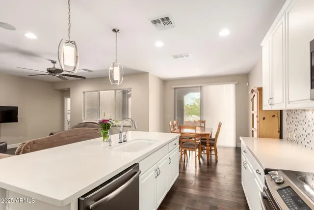 a kitchen with stainless steel appliances granite countertop a sink a stove and a wooden floors