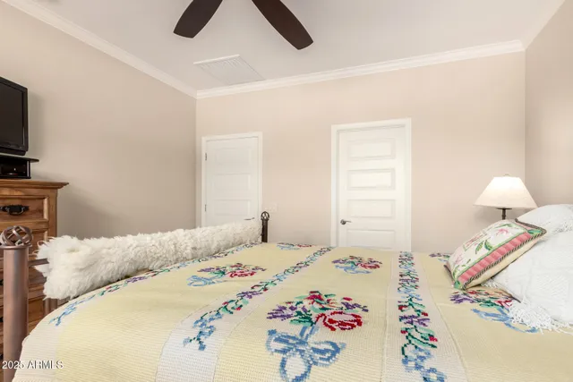 a bedroom with a bed and a flat tv screen on a dresser