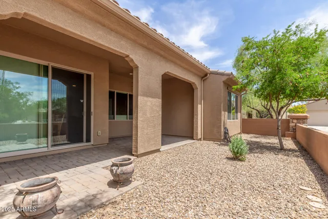 a view of a house with a small yard and sitting area