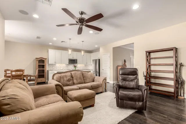 a living room with furniture and a ceiling fan