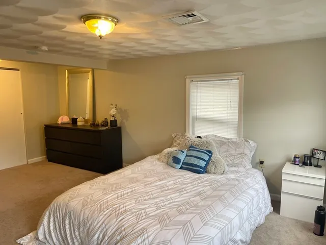 a bedroom with a bed and a potted plant