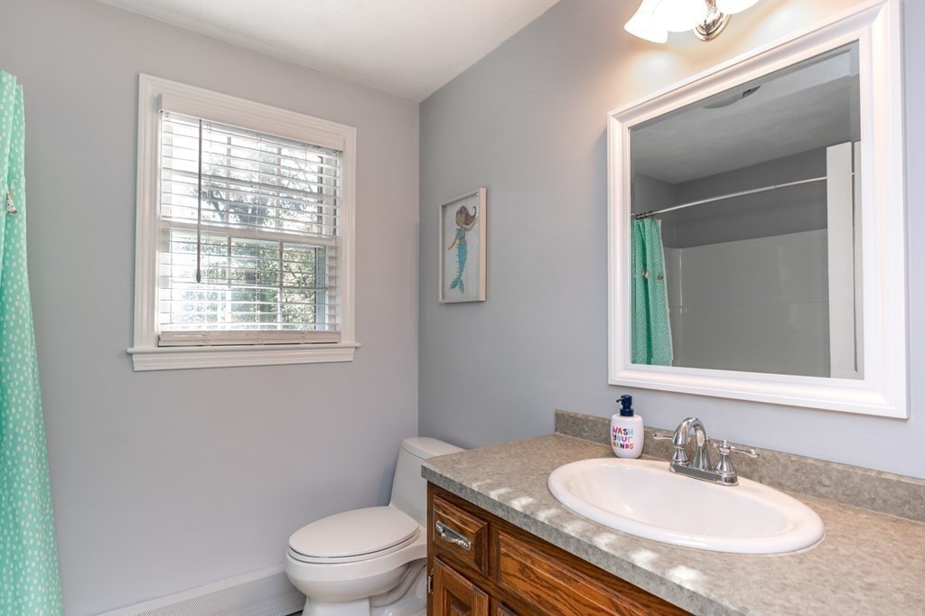 119 Gayland Road Needham, MA 02492 - Photo 29 of 42 a bathroom with a granite countertop sink toilet a mirror and a window
