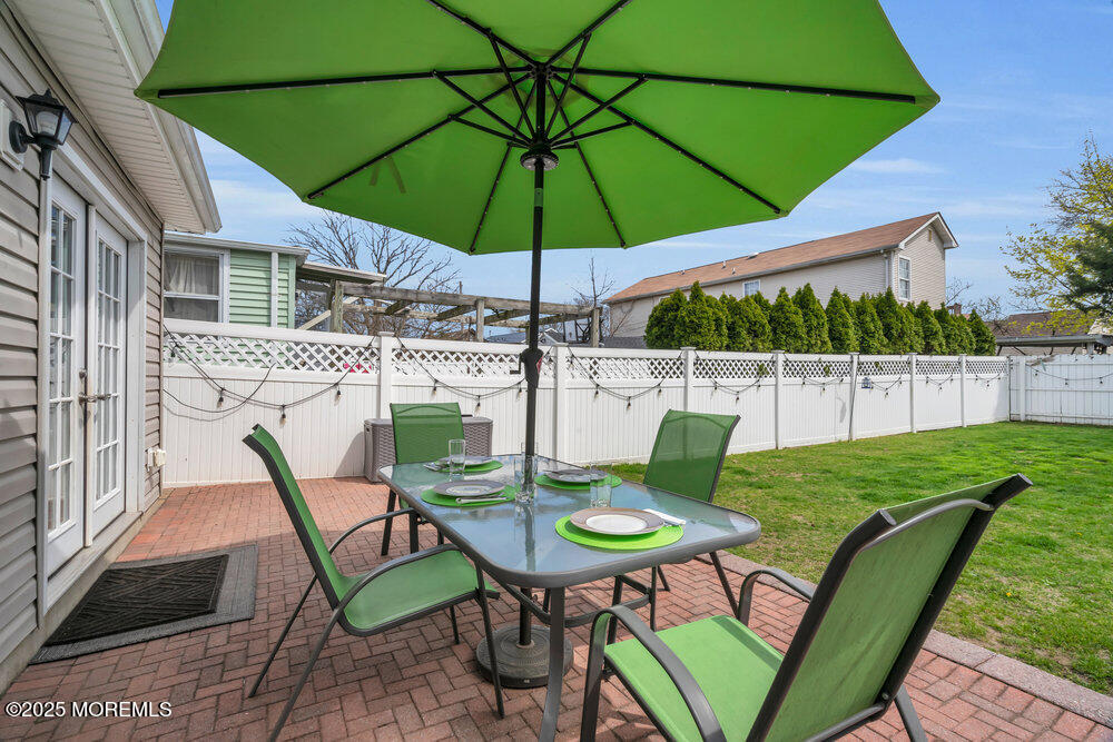 108 Maple Place Keyport, NJ 07735 - Photo 22 of 26 a patio with a table and chairs under an umbrella