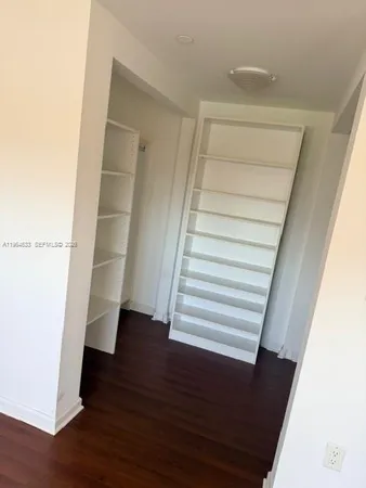 a view of a room with wooden floor fan and window