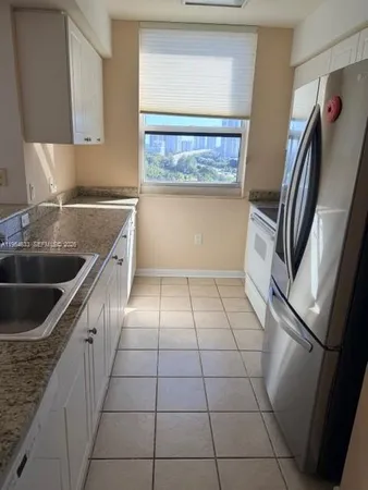 a kitchen with a sink a refrigerator and window