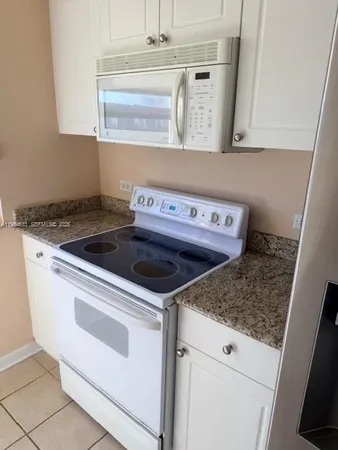 a kitchen with granite countertop a sink and a stove
