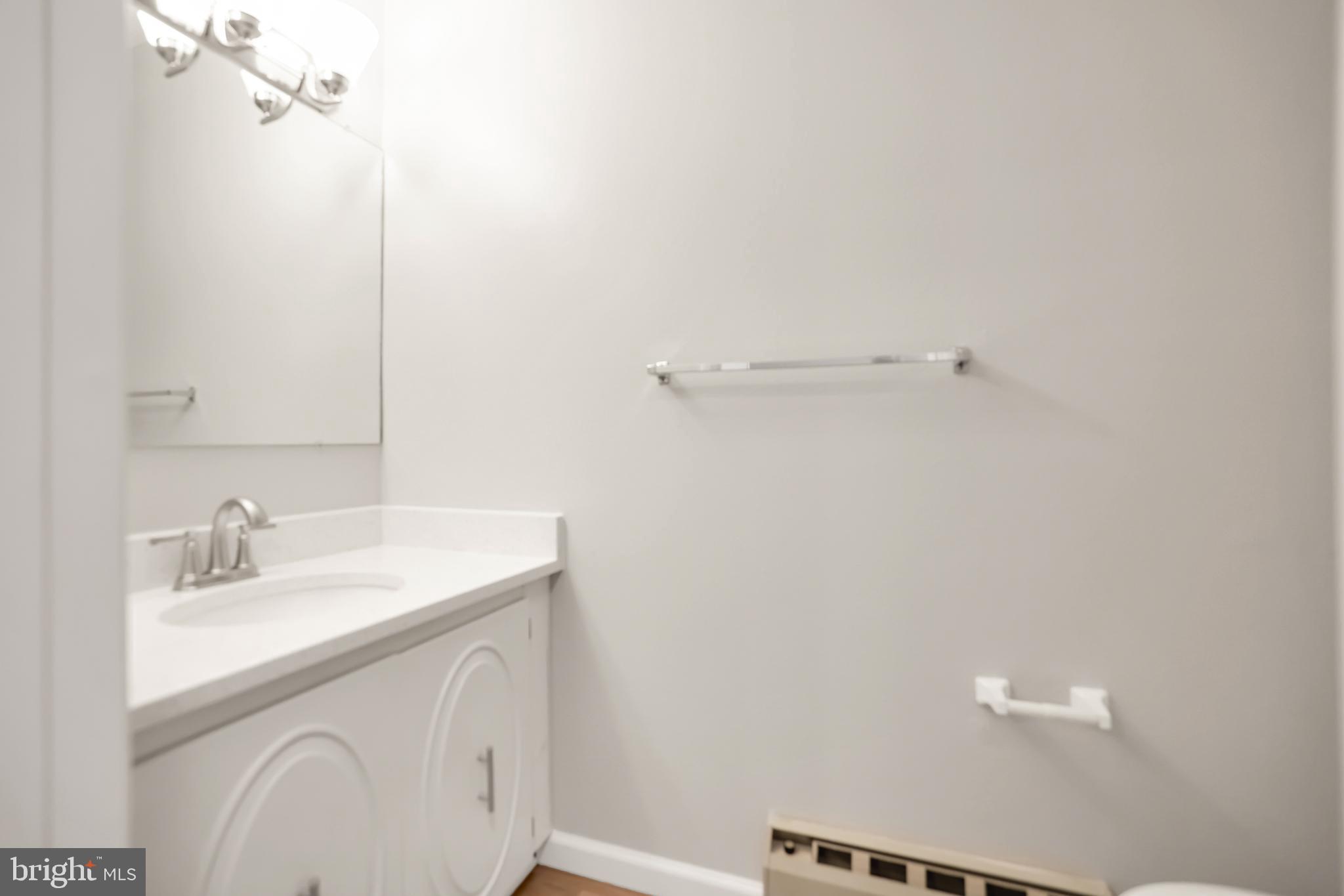 15121 Glade Drive, Unit 132F Silver Spring, MD 20906 - Photo 14 of 27 a bathroom with a sink a vanity and a mirror