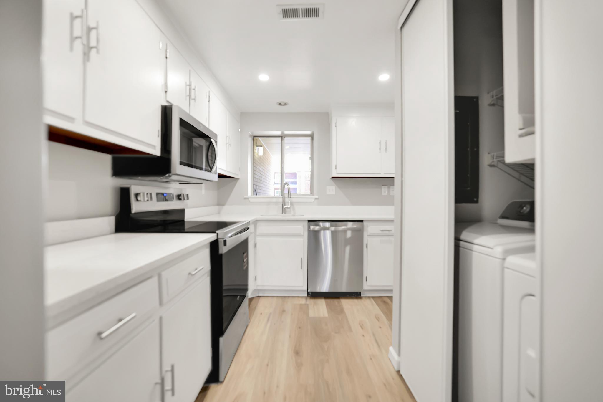 15121 Glade Drive, Unit 132F Silver Spring, MD 20906 - Photo 10 of 27 a kitchen with stainless steel appliances granite countertop a sink a stove a refrigerator and cabinets